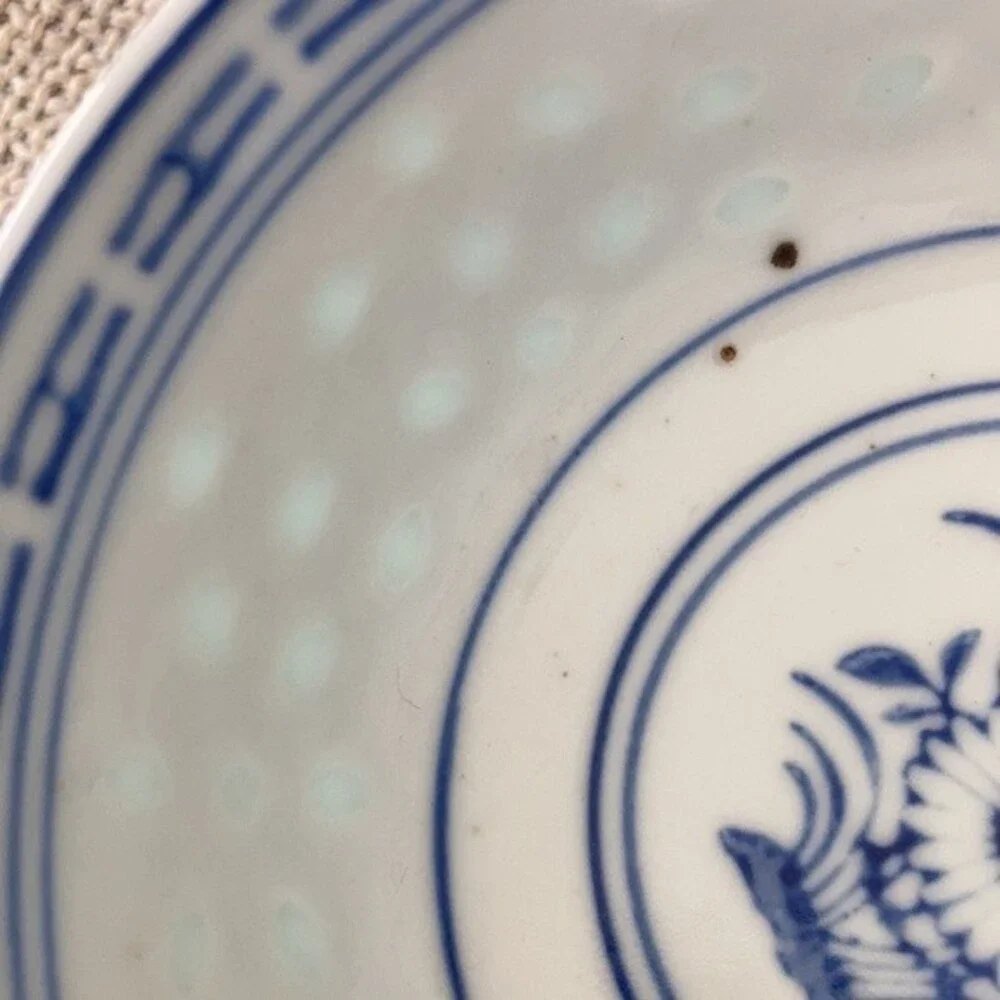 Small Chinese blue white porcelain bowl with brown glaze specks.